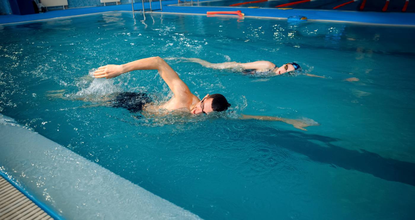 kobieta z mężczyzną płyną w okularach w basenie